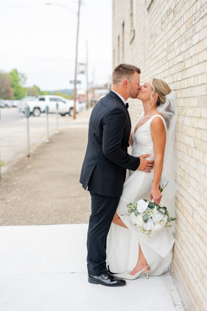 wedding couple in pittsburgh kissing for their portraits in ford city